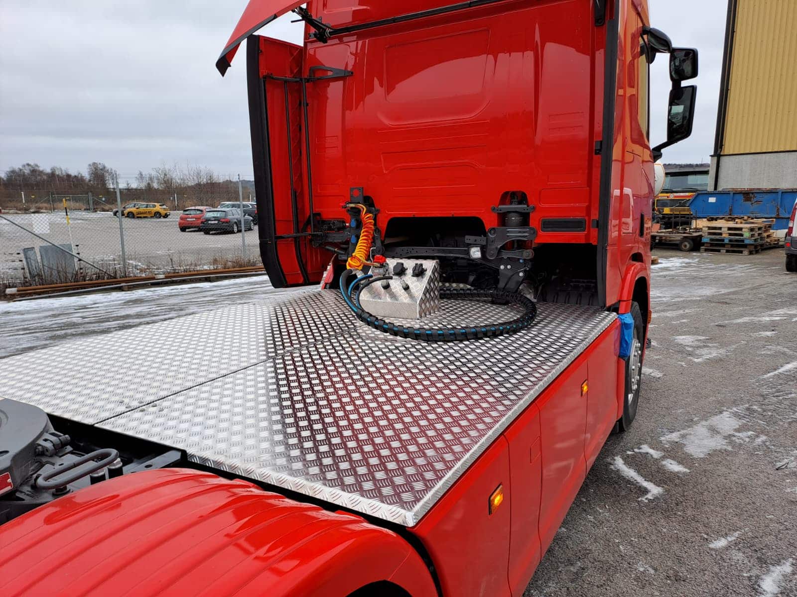 Gångbordet monterat mot hytten, med kopplingsbox och luftslang synliga i aluminiumkonstruktionen.